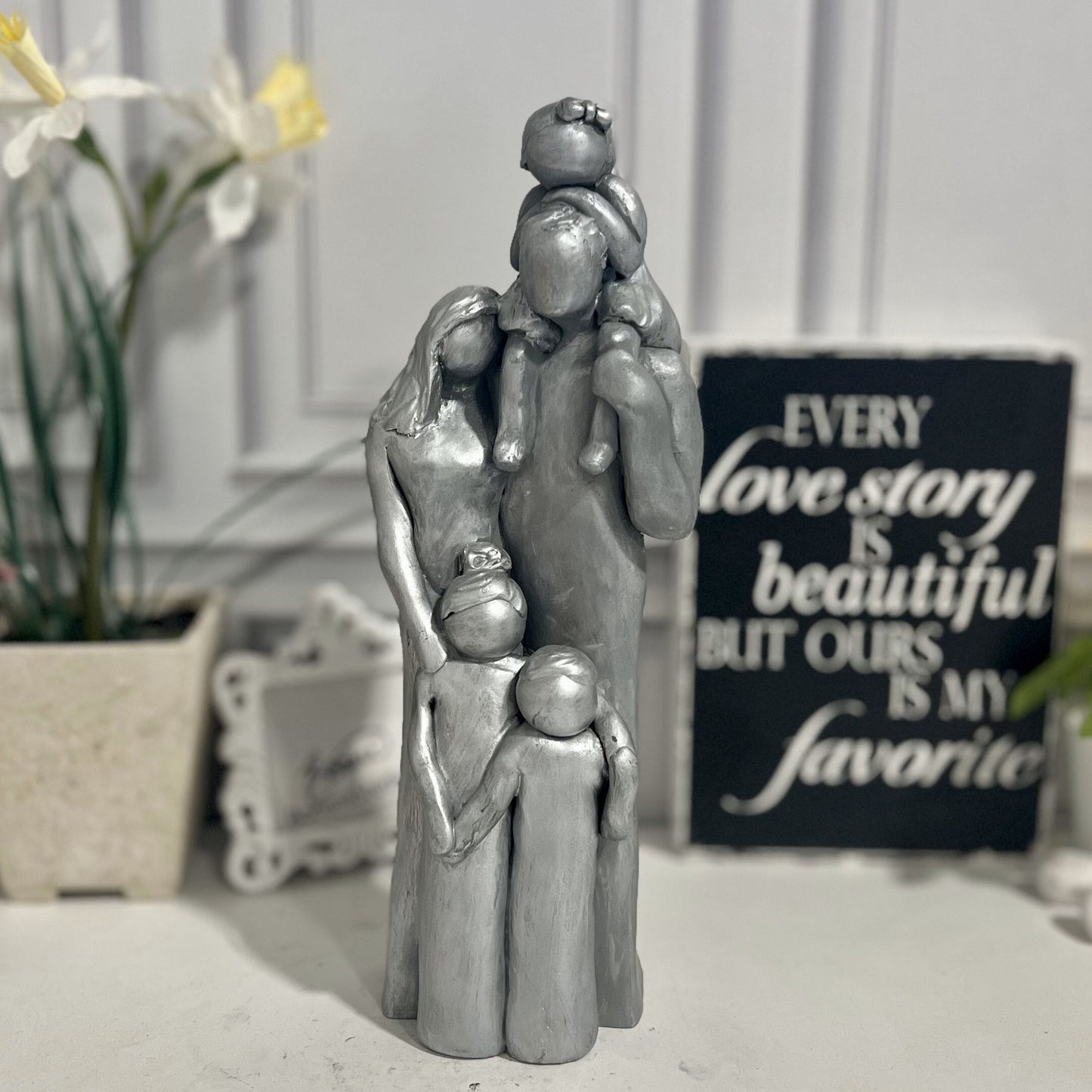 Aluminum 10th Anniversary Family Sculpture with three children, one one is on the dad's shoulders. The younger two are boy/girl twins w. The older child is a girl