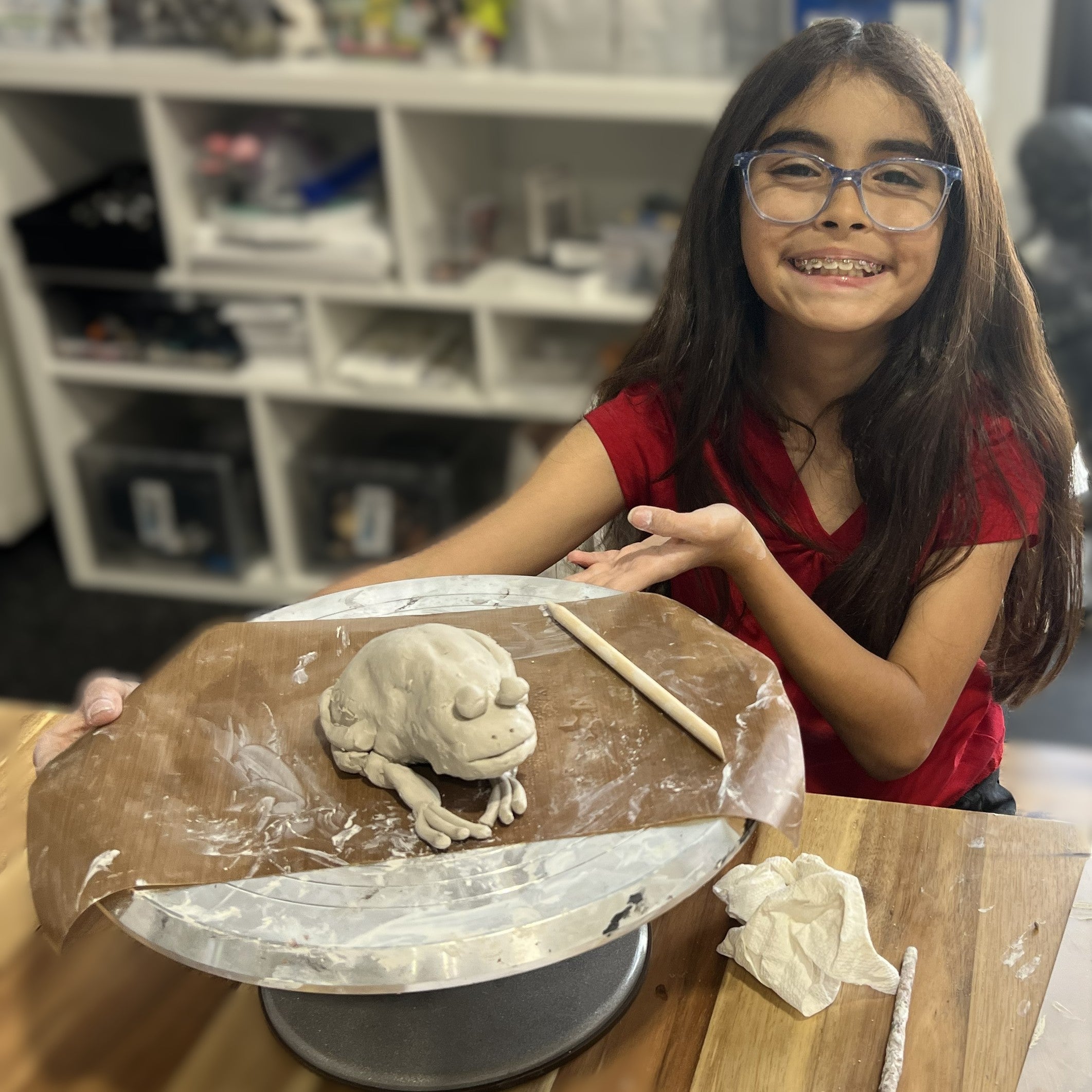 kid sculpting ceramic clay frog  at art birthday party bonura studios hutto texas
