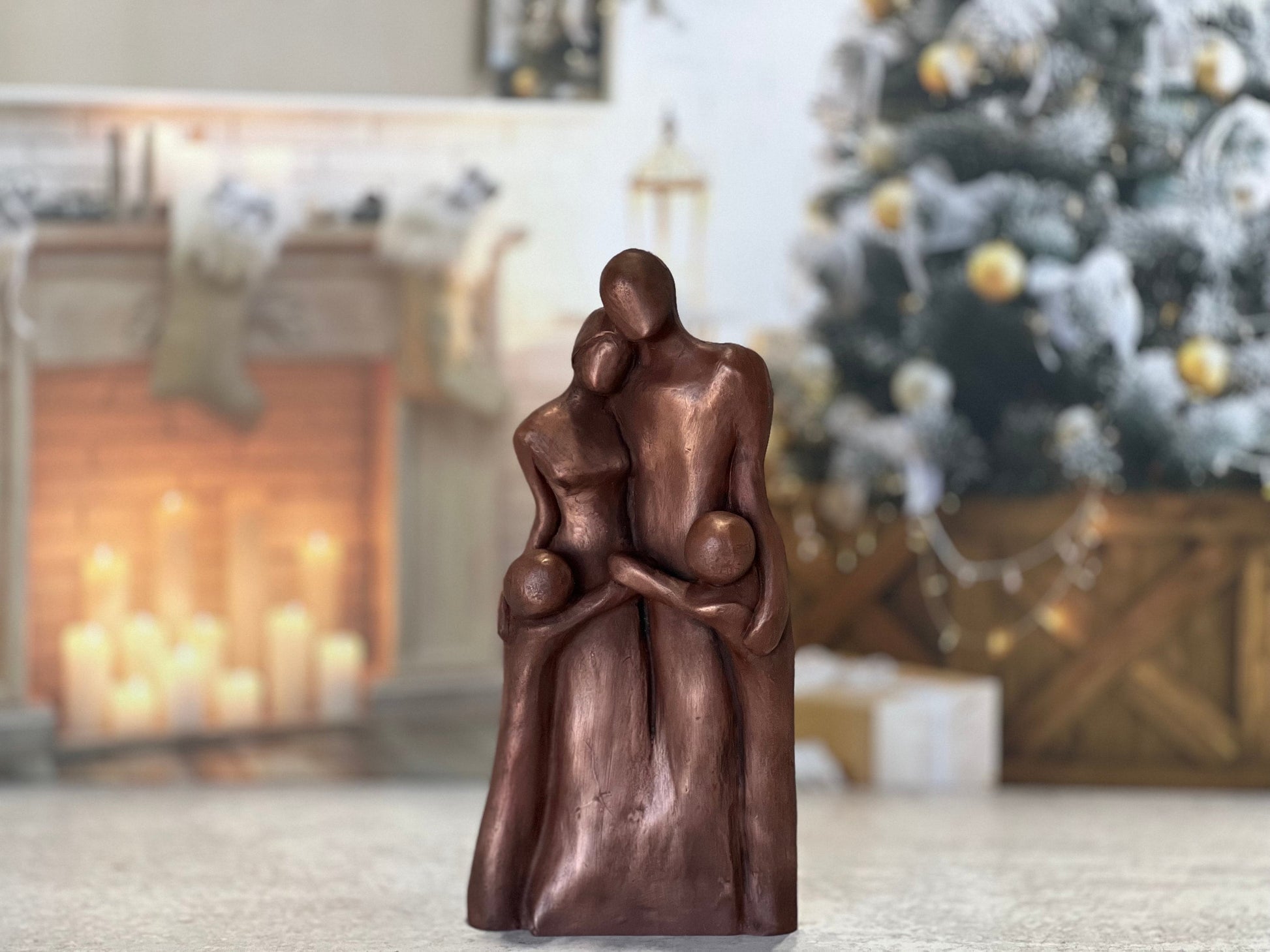 A copper family of four sculpture with two boys hugging their parents in a Family Hug!