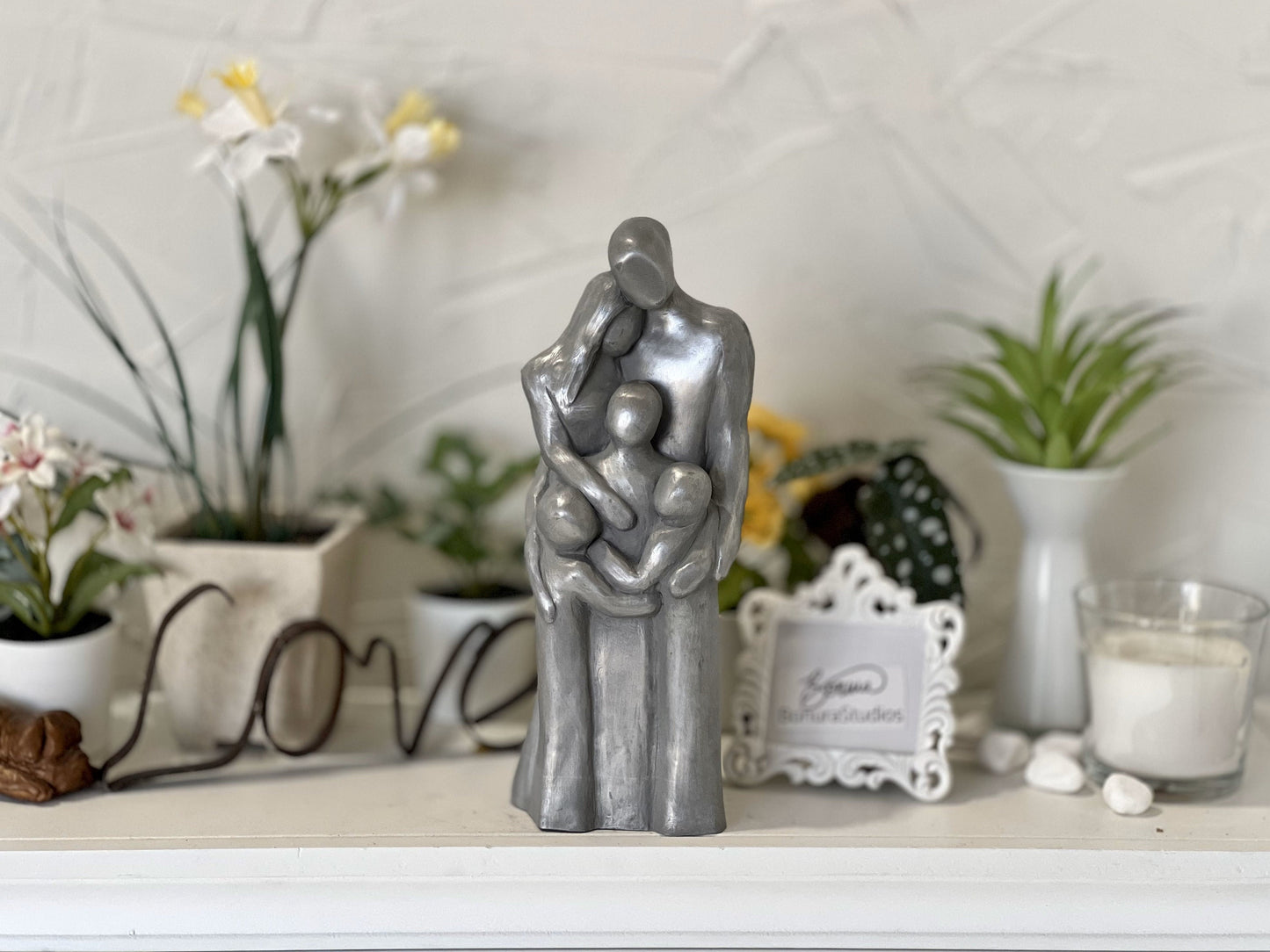 Aluminum Family of Five Sculpture with three children all hugging each other.